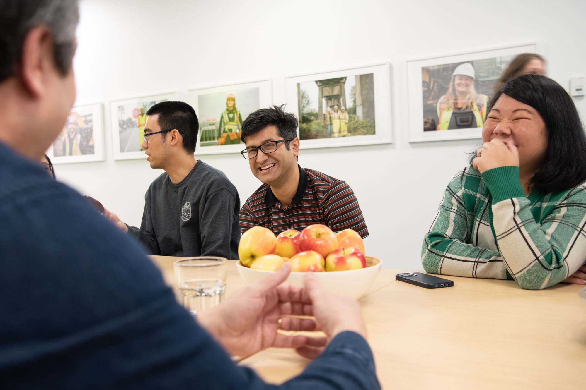 A picture of people in a meeting smiling and laughing.