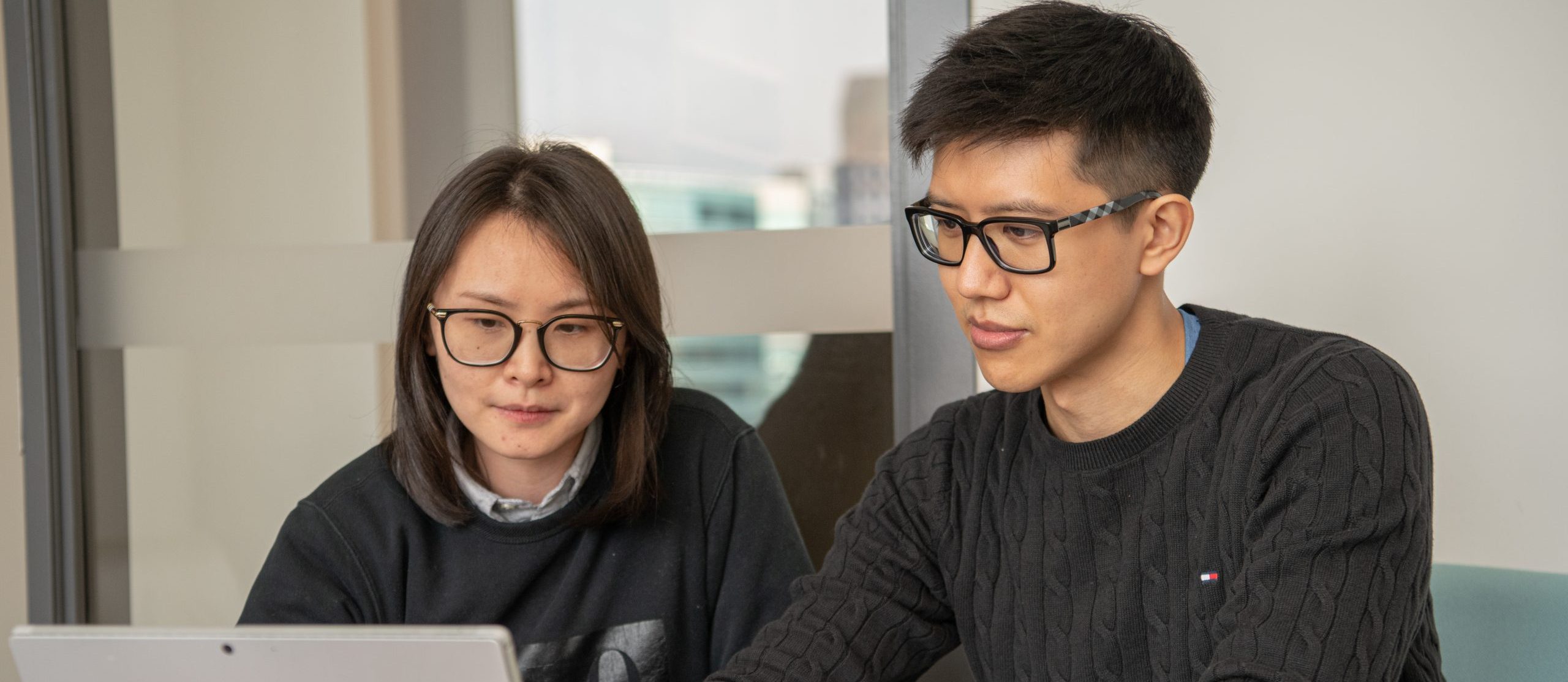 An image of a man and woman looking at a computer