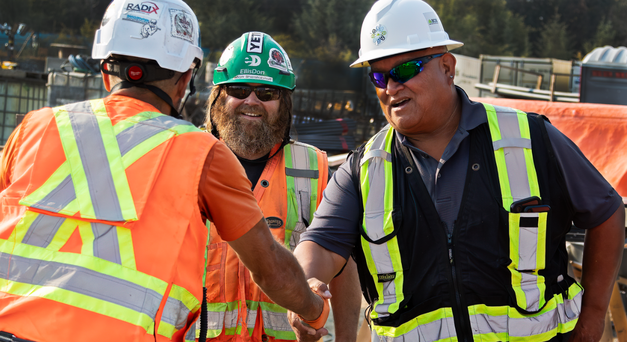 Bubba, BCIB Cultural Advisor and Red Seal Plumber, shakes hands with two other workers on the Cowichan District Hospital Replacement Project.