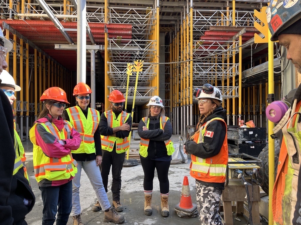 Workers on a construction site with scaffolding in the background